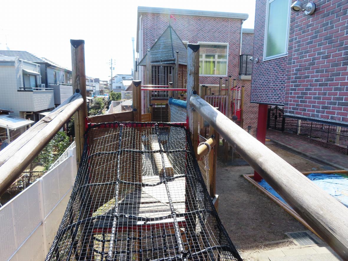 木製遊具の上部にある、ネットが張られた渡り廊下部分